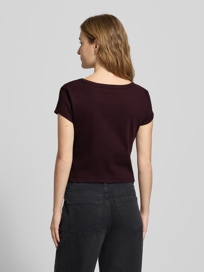 Modelka nosi Cropped T-Shirt mit Label-Detail von Calvin Klein Jeans, bawełna z elastanem, okrągły dekolt, długość pleców S: 43 cm, widok całej sylwetki od tyłu