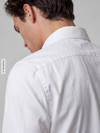 Männermodel trägt weißes Slim Fit Businesshemd aus reiner Baumwolle Modell 'New Kent Patch' von Seidensticker, Nahaufnahme Rückansicht. Herren Businesshemd von Seidensticker.