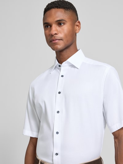 Männermodel trägt Regular Fit Business-Hemd mit Kentkragen von OLYMP, weiß, reine Baumwolle, unifarben, Nahaufnahme Oberkörper.