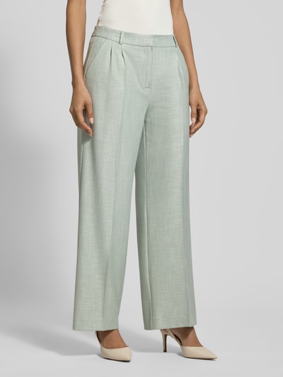 Vrouwenmodel draagt Wide Fit Stoffhose aus Viskose-Mix mit Bügelfalten van comma in lichtgroen, elastische stof, siernaden, zij- en achterzakken, haak- en ritssluiting, taillewijdte 40 cm, binnenbeenlengte 75 cm, Ganzkörperaanzicht van voren.