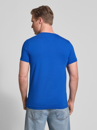 Männermodel trägt Slim Fit T-Shirt aus Baumwoll-Mix von Tommy Hilfiger in Unifarben Blau, Logo-Detail, kurzarm, Rückansicht Ganzkörperansicht.
