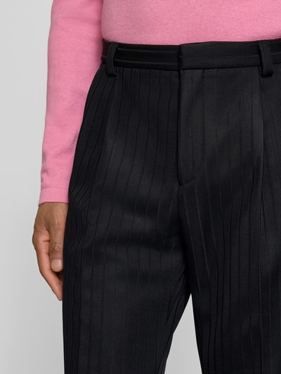 Mężczyznamodel nosi Regular Fit Anzughose aus Viskose-Mix Modell 'HESTEN' od HUGO, czarny twill, pionowy wzór, paski, widoczne zakładki i kieszenie, zapięcie na haczyk i kryty zamek, krój regular fit, widoczne szlufki na pasek, detalowe zdjęcie talii i górnej części spodni, z przodu