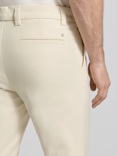 Männermodel trägt Regular Fit Chino aus Baumwoll-Mix Modell 'KANE1' von BOSS in Creme mit Logo-Applikation, Detailaufnahme Rückansicht.