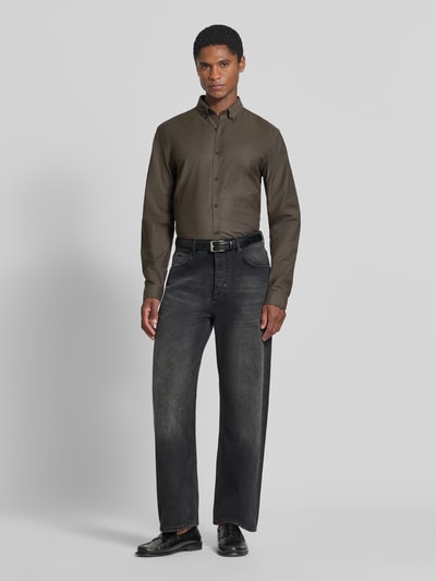 Männermodel trägt Regular Fit Freizeithemd aus Baumwoll-Mix Modell 'Oxford' von Lindbergh in Oliv, Kombination aus glatter und matter Textur, Ganzkörperansicht von vorne. Kontext: Herren Freizeithemd, Baumwoll-Elasthan-Mix, Button-Down-Kragen, 1-Knopf-Manschetten, abgerundeter Saum, Rückenlänge 77 cm, Schulterbreite 44 cm, Ärmellänge 66 cm.