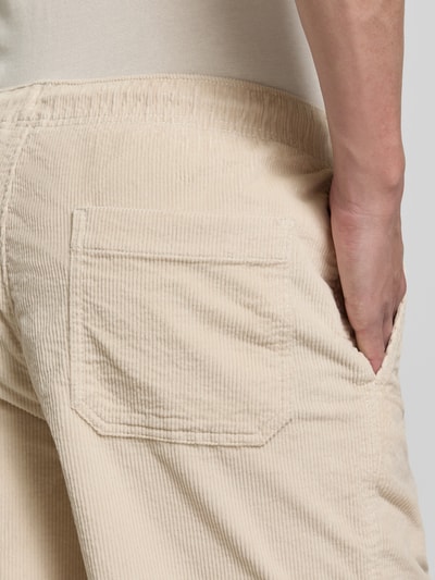 Mężczyznamodel nosi Regular Fit Sweatshorts aus Baumwoll-Mix od SELECTED HOMME, kremowy, sztruksowy materiał, kieszeń tylna, zbliżenie tylnego widoku.