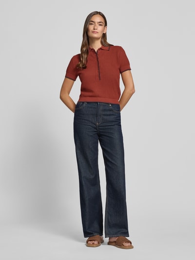 Vrouwenmodel draagt gebreid shirt met polokraag en knoopsluiting model 'MEROPE' van DRYKORN, puur katoen, regular fit, donkerrood, ruglengte maat S 50 cm, mouwlengte 20 cm, donkerblauwe jeans, sandalen, geheellichaamsaanzicht van voren