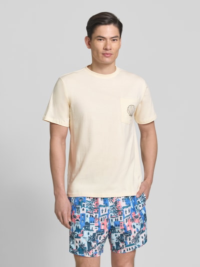 Männermodel trägt T-Shirt mit Brusttasche und Stitching Modell 'Ilfracombe' von BOARDIES, Reine Baumwolle, Regular-Fit, Rundhalsausschnitt, Creme, Brusttasche mit Stickerei, Rückenlänge bei Größe M 71 cm, Ganzkörperansicht von vorne.