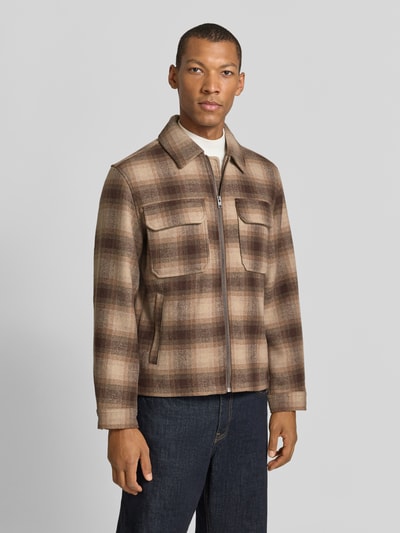 Mężczyzna nosi Regular Fit Hemdjacke mit Brusttaschen Modell 'WAKEFIELD' od JACK & JONES Premium, beżowo-brązowa krata, długie rękawy, kołnierz kent, zamek błyskawiczny, tekstura miękka, długość tyłu w rozmiarze M 66 cm, Ganzkörperansicht von vorne.
