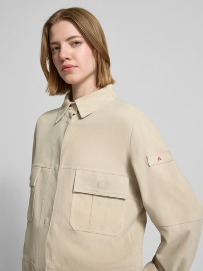 Frauenmodel trägt Lederjacke mit Pattentaschen Modell 'Era' von Peuterey in Beige mit Kentkragen, Druckknöpfen, Nahaufnahme Oberkörper.
