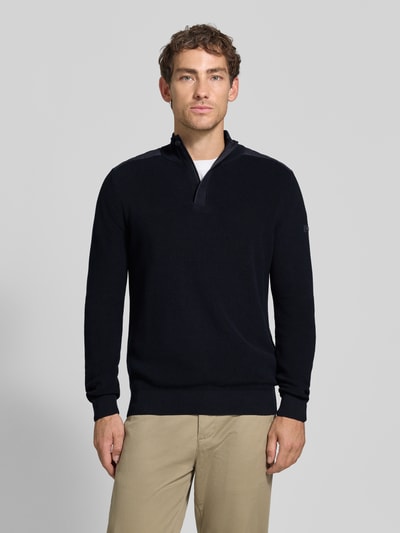 Männermodel trägt gebreide pullover met schoudervullingen van bugatti in donkerblauw, puur katoen, recht model, schipperskraag, ribboorden, ruglengte bij maat M 68 cm, mouwlengte bij maat M 70 cm, ganzkörperansicht van voren.