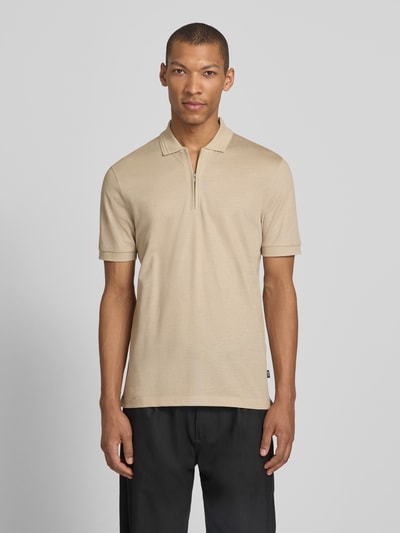 Männermodel trägt Regular Fit Poloshirt aus Baumwoll-Lyocell-Mix Modell 'H-PARAS 70' von BOSS in Beige, unifarben, Ganzkörperansicht von vorne.