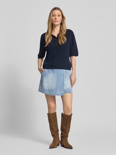 Frauenmodel trägt Hosenrock mit Gesäßtaschen von ARMANI EXCHANGE aus Baumwoll-Mix mit Stretch-Anteil, Gerader-Schnitt, Minirock, Knopfverschluss, hellblaue Waschung, glatte Textur, Ganzkörperansicht von vorne.