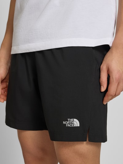 Männermodel trägt Regular Fit Shorts mit Eingrifftaschen von The North Face in Schwarz, elastischer Bund, Nahaufnahme Oberschenkel, Herren Shorts.