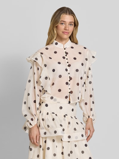 Vrouwenmodel draagt Boxy Fit Chiffon-blouse met polkadots-motief model 'DOROTHY' van Vero Moda, semi-transparant, all-over motief, ballonmouwen, ruches, stoffen band, knoopsluiting, mock neck kraagmodel, boxy fit pasvorm, materiaalverwerking chiffon, vooraanzicht bovenlichaam.
