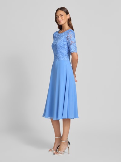Vrouwenmodel draagt knielanges Cocktailjurk met kant en ronde halsuitsnijding van Vera Mont in blauw chiffon, a-lijn, ruglengte maat 36: 105 cm, borstwijdte maat 36: 40 cm, mouwlengte maat 36: 28 cm. Volledige lichaamsvooraanzicht.