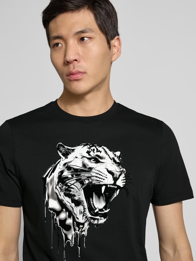 Männermodel trägt T-Shirt mit Label-Detail von Antony Morato in Schwarz, reine Baumwolle, Regular-Fit, gerippter Rundhalsausschnitt, Nahaufnahme Oberkörper. Rückenlänge bei Größe M: 70 cm.