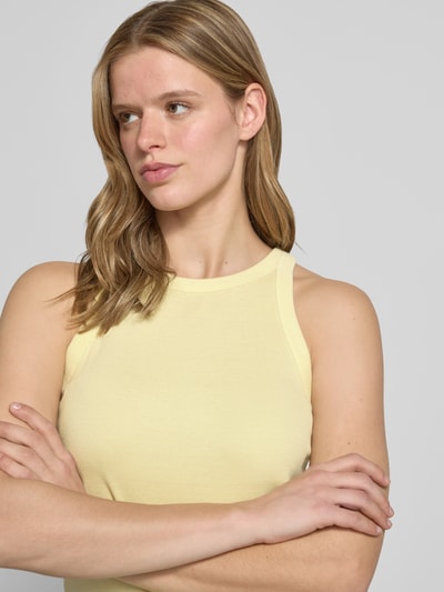 Vrouwenmodel draagt Slim Fit Tank Top aus reiner Baumwolle van Levi's®, uni geel, ribstructuur, label print, U-hals, brede bandjes, slim fit, puur katoen, borst detailopname