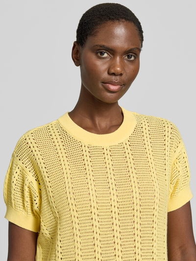 Frauenmodel trägt Relaxed Fit Strick-Shirt aus Baumwoll-Mix Modell 'LUX LIGHT' von Vero Moda in Gelb mit Lochstrickmuster, Nahaufnahme Oberkörper.