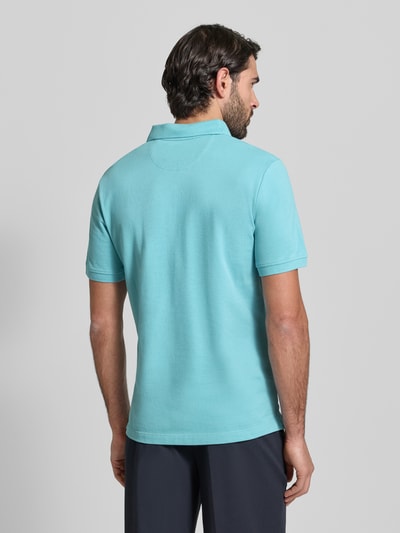 Männermodel trägt Regular Fit Poloshirt aus reiner Baumwolle von s.Oliver RED LABEL in Uni-Azur, Piqué-Struktur, Ganzkörperansicht Rückansicht.