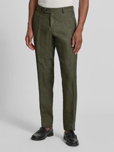 Männermodel trägt Slim Fit Leinenhose aus reinen Leinen Modell 'Tomte' von Carl Gross, olivgrün, Bügelfalten, Gesäßtaschen, Knopf- und Reißverschluss, Bundweite 45 cm, Innenbeinlänge 84 cm, Ganzkörperansicht von vorne.