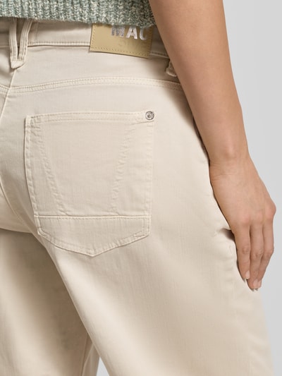 Frauenmodel trägt Stoffhose mit 5-Pocket-Design Modell 'DANNI' von MAC in Beige, Baumwoll-Mix mit Stretch-Anteil, Nahaufnahme Rückansicht.