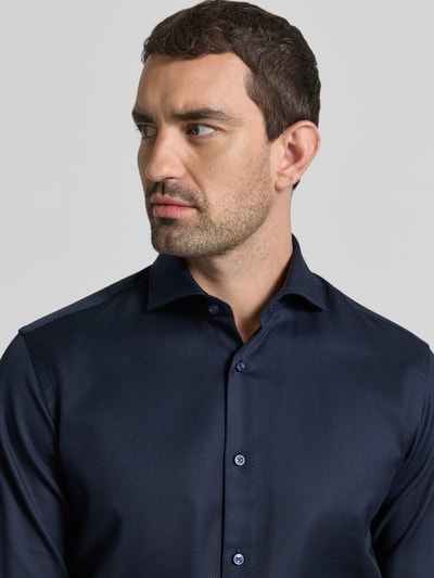 Męski model nosi Regular Fit Businesshemd aus reiner Baumwolle model 'H-JOE-SP' od BOSS, granatowy, strukturalny materiał, zbliżenie na górną część ciała, koszule biznesowe