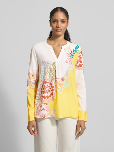 Vrouwenmodel draagt Regular Fit Bluse aus Seide-Elasthan-Mix mit Allover-Look van HERZENS, gele en witte tinten, tuniekkraag, hele lichaam van voren.