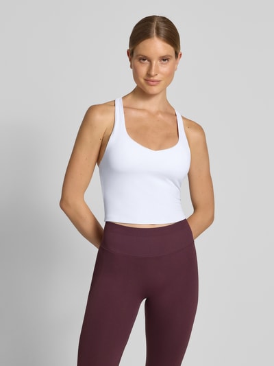 Frauenmodel trägt Slim Fit Top mit integriertem Bustier Modell 'Anywhere' von Fabletics in Weiß, elastischer Material-Mix, Nahaufnahme Oberkörper.
