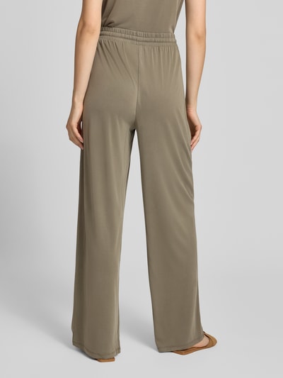 Frauenmodel trägt Weite Hose aus Viskose-Mix Modell 'ANORA' von PIECES in Olivgrün, lockerer Schnitt, glatte Textur, Ganzkörperansicht Rückansicht. Damen Weite Hose von PIECES.