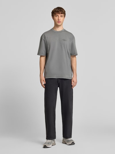 Männermodel trägt Oversized Fit T-Shirt mit Logo-Stitching von Pegador in Grau aus Reine Baumwolle, Rundhalsausschnitt, Herren T-Shirt, Ganzkörperansicht von vorne.