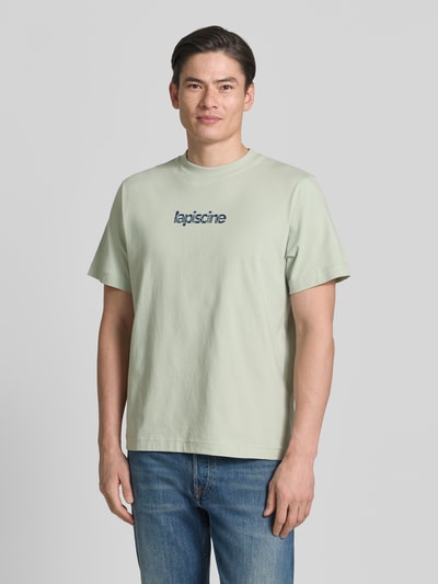 Männermodel trägt Regular Fit T-Shirt aus reiner Baumwolle Modell 'HASPEN' von SELECTED HOMME, Optik: Unifarben, Schriftzug, Rundhals, Kurzarm, Ganzkörperansicht von vorne.