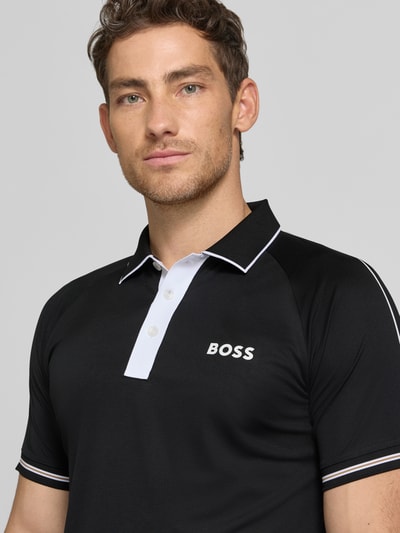 Männermodel trägt Regular Fit Poloshirts mit Kontrastdetails von BOSS Green in Schwarz-Weiß, Two Tone Optik, Nahaufnahme Oberkörper.