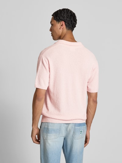 Männermodel trägt Regular Fit Poloshirt in Strick-Optik von Closed in hellem Rosa aus Baumwoll-Mix, kurzärmelig, Rückenlänge 72 cm, Ganzkörperansicht Rückansicht.
