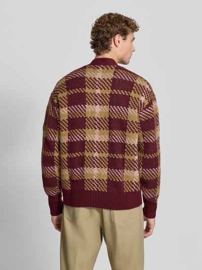 Männermodel trägt Relaxed Fit Strickjacke mit Allover-Muster Modell 'MARIAN' van Jake*s Studio Men in rood en beige met ruitpatroon, gebreide textuur, Ganzkörperansicht Rückansicht.
