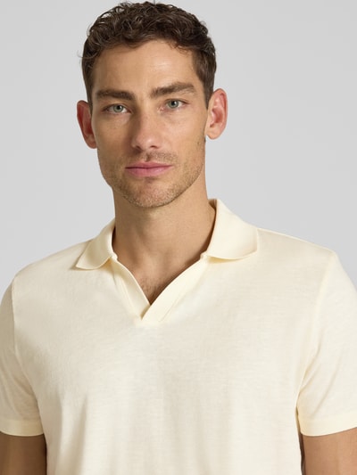 Männermodel trägt Slim Fit Poloshirt mit V-Ausschnitt von MCNEAL in Creme, reine Baumwolle, Polokragen, Nahaufnahme Oberkörper.