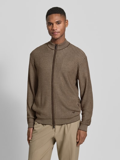 Männermodel trägt Strickjacke mit Woll-Anteil von Emporio Armani in Beige-Braun mit Stehkragen und Zweiwege-Reißverschluss, Nahaufnahme Oberkörper. Materialmix mit Lyocell, elastische Abschlüsse, gerade Passform.