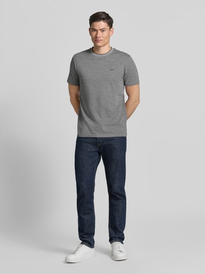 Männermodel trägt T-Shirt mit Rundhalsausschnitt und Label-Stitching von Gant, Reine Baumwolle, Regular-Fit, Rückenlänge 69 cm, Ganzkörperansicht von vorne.