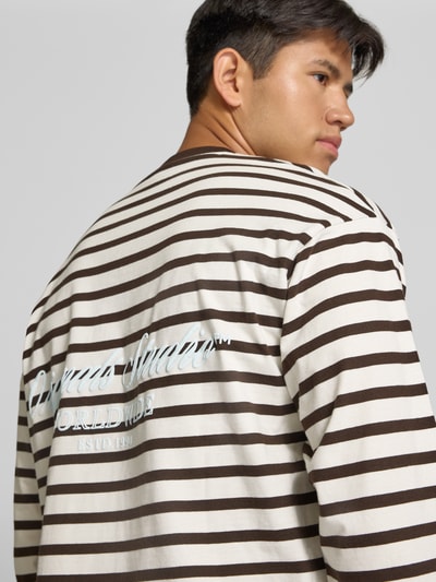 Männermodel trägt Regular Fit Longsleeve aus reiner Baumwolle mit Streifenmuster von JACK & JONES, Beige-Braun, Nahaufnahme Oberkörper.