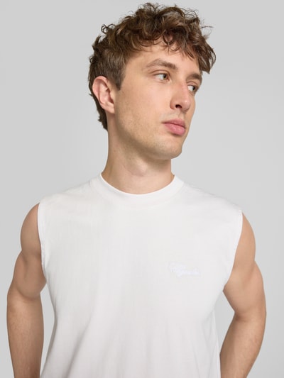 Männermodel trägt Tanktop mit Label-Stitching und Rundhalsausschnitt von Pegador aus Reine Baumwolle im Relaxed-Fit, Nahaufnahme Oberkörper.