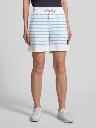 Frauenmodel trägt Shorts mit Label-Detail und Tunnelzug von Marc Cain in Weiß mit hellblauem Streifenmuster, Regular Fit, Baumwoll-Mix, Nahaufnahme Oberkörper.