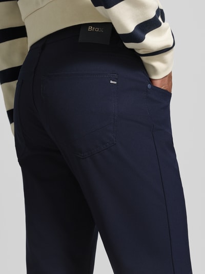 Männermodel trägt Hose mit Eingrifftaschen Modell 'Chuck' von Brax in Dunkelblau, Regular Fit, Material-Mix, Nahaufnahme Rückansicht.