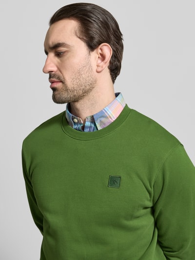 Männermodel trägt sweatshirt met ronde hals van Scotch & Soda in groen, puur katoen, regular fit, labelstitching, Nahaufnahme Oberkörper.
