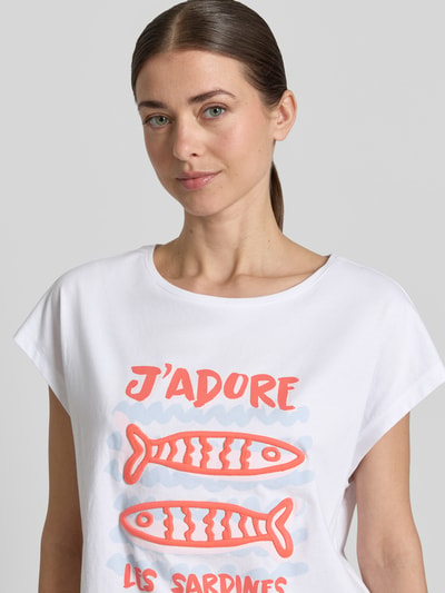 Frauenmodel trägt Oversized T-Shirt mit Motiv-Print von Smith and Soul in Weiß mit rotem Print, reine Baumwolle, Nahaufnahme Oberkörper.