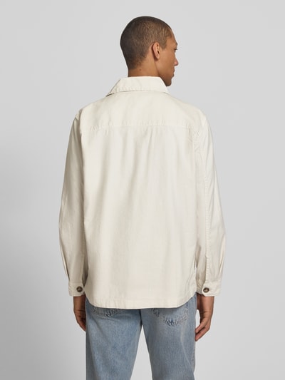 Männermodel trägt Regular Fit Hemdjacke aus Leinen-Mix von Gant in Creme mit Umlegekragen, lockere Passform und aufgesetzten Taschen, Ganzkörperansicht Rückansicht.