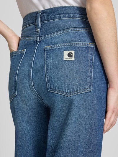 Frauenmodel trägt Tapered Fit Jeans im 5-Pocket-Design von Carhartt Work In Progress aus reiner Bio-Baumwolle, Detailaufnahme Rückansicht.