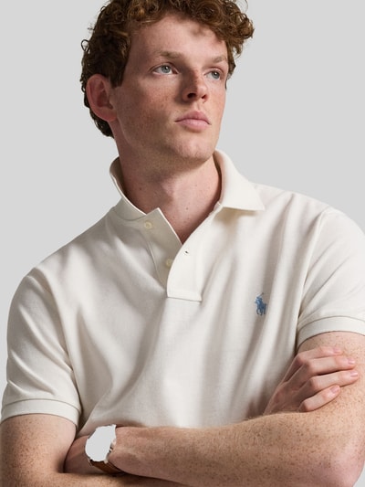 Männermodel trägt Regular Fit Poloshirt aus reiner Baumwolle von Polo Ralph Lauren in Unifarben mit Logo-Detail, Nahaufnahme Oberkörper.