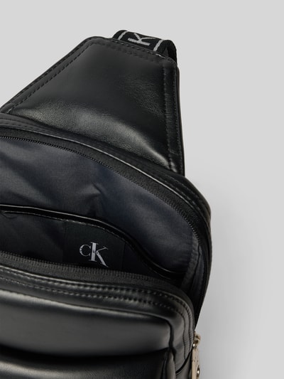 Produktfoto, czarna torba na ramię Herren Umhängetasche mit Label-Prägung od CK Calvin Klein, gładka faktura, srebrny zamek, widok z góry na otwartą kieszeń