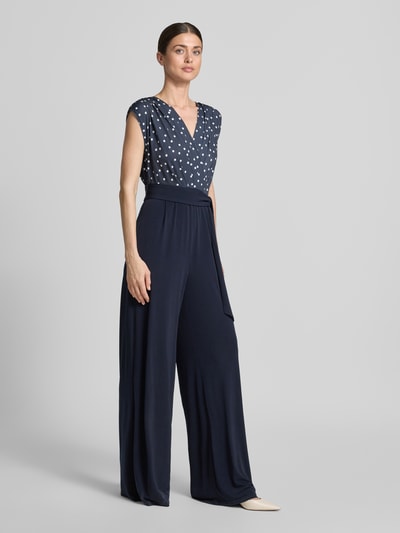 Vrouwenmodel draagt Regular Fit Jumpsuit met V-hals van Vera Mont, donkerblauwe elastische materiaalmix, tailleband, geplooid, mouwloos design, getailleerde pasvorm, voorkant volledige lichaamsopname