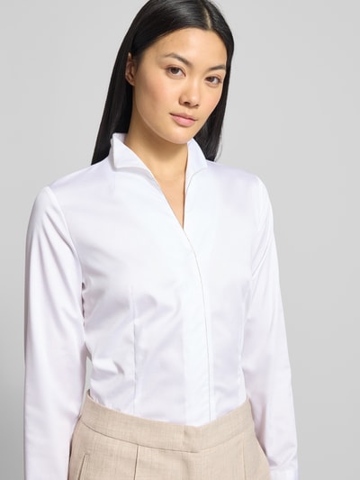 Frauenmodel trägt Hemdbluse mit Stehkragen von Eterna aus Baumwoll-Elasthan-Mix, lockerer Schnitt, verdeckte Knopfleiste, Nahaufnahme Oberkörper.