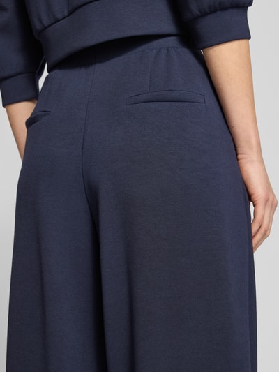 Frauenmodel trägt Sweatpants mit elastischem Bund von Rich & Royal in Dunkelblau, weiche Struktur, Gesäßtaschen, Nahaufnahme Oberkörper.